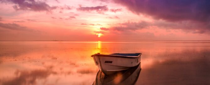 purple and orange sunset with a boat