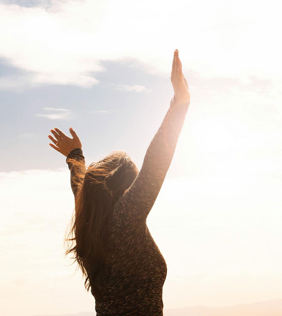 lady with her hands up and clouds in the background