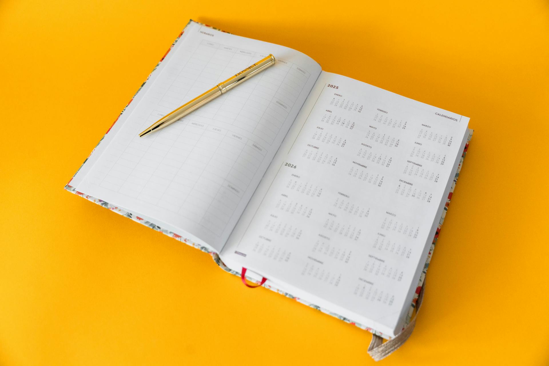 planner open with a a pen and yellow background
